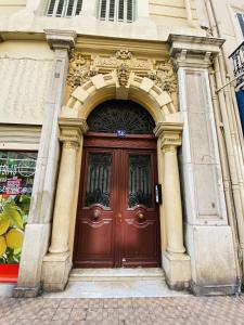 une grande porte marron sur un bâtiment dans l'établissement Corso Home- central apartment in Menton, à Menton