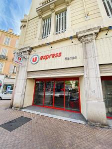 un devant de magasin avec portes rouges sur un bâtiment dans l'établissement Corso Home- central apartment in Menton, à Menton