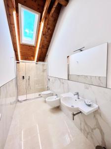 La salle de bains est pourvue de 2 lavabos, de toilettes et d'une fenêtre. dans l'établissement La Villa Carmelina, à Agerola