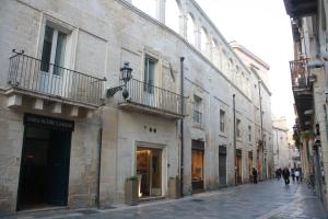 eine Stadtstraße mit Gebäuden und Menschen, die auf der Straße spazieren in der Unterkunft La Dimora di Paola in Lecce