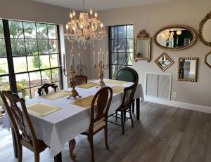comedor con mesa, sillas y lámpara de araña en Phantom History House Castle Room en Tampa