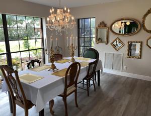 a dining room with a table and chairs and a chandelier at Phantom History House Castle Room in Tampa