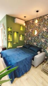 a bedroom with a blue bed and a green wall at Studio de charme climatisé Gare Riquier in Nice