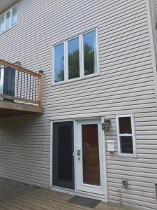 a house with a white door and a balcony at Lovely private one bedroom apartment in Kanata in Ottawa