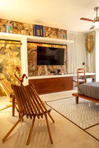 a living room with a television on a stone wall at La Parcela Cunkal in Conkal