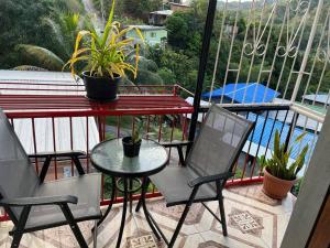 a balcony with two chairs and a table with plants at Kavi Crescent Snug Retreat 2BR with Queen bed in Petit Valley