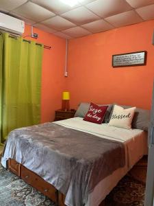 a bedroom with orange and green walls and a bed at Kavi Crescent Snug Retreat 2BR with Queen bed in Petit Valley