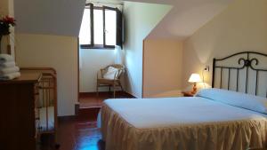 1 dormitorio con cama, ventana y silla en Camín de la reina, en San Juan de Parres
