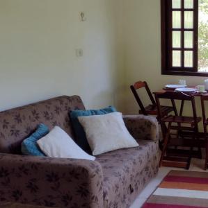 uma sala de estar com um sofá e uma mesa em Casa de Campo no Parque Estadual da Serra do Mar em São Luiz do Paraitinga