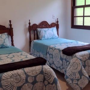 a bedroom with two twin beds and a window at Casa de Campo no Parque Estadual da Serra do Mar in São Luiz do Paraitinga