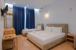 a bedroom with a large bed and a night stand at Otto Hotel in Ksamil