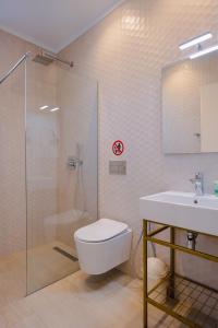 a bathroom with a toilet and a sink and a shower at Otto Hotel in Ksamil