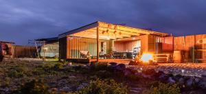 a small house with a fire in front of it at TREKOS GLAMPING in Jacobs Bay