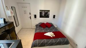 a small bedroom with a bed with red pillows at Sweet Home Marceau 6 studios hyper centre proche de la mer et du palais in Cannes