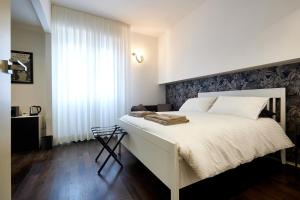 sypialnia z białym łóżkiem i oknem w obiekcie Suite in Town w Bolonii