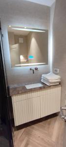 La salle de bains est pourvue d'un lavabo et d'un miroir. dans l'établissement KOTEL HOTEL, à Jérusalem