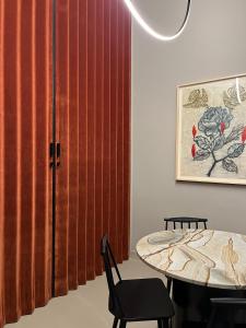 a dining room with a table and a red curtain at Casa Caleido in Verona