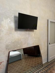 TV de pantalla plana colgada en la pared en Casa Caleido, en Verona