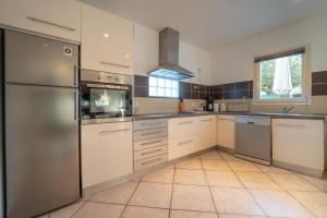 uma cozinha com electrodomésticos em aço inoxidável e pisos em azulejo em L'ALIVETTE em Bastelicaccia