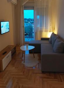 a living room with a couch and a table at Lena Apartman in Subotica