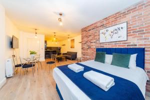 a bedroom with a large bed and a brick wall at MORDEN STUDIO CENTRAL BRIGHTON LOCATION Sleep 3 Guests in Brighton & Hove