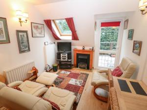 un soggiorno con divani, TV e camino di Chestnut Apartment a Cheltenham