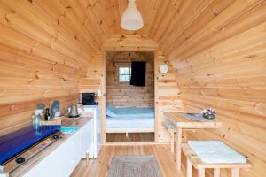 een blokhut met een bed en een bureau bij Tiny Camping Pod in Warmond