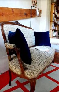 a chair with blue pillows and a book on it at Aux berges du pont du gard in Vers Pont du Gard
