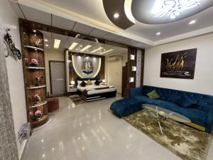 a living room with a blue couch and a chair at Hotel Buddha International in Patna