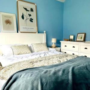 um quarto com uma cama e uma parede azul em Killenard Kottage, Killenard, Laois em Killenard