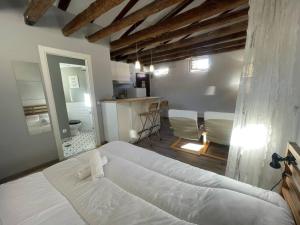 a bedroom with a large white bed and a kitchen at Punta Me Beautiful Apartment in Plaza España in Madrid