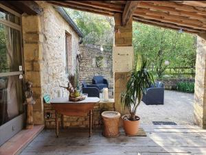 patio esterno con tavolo e pianta in vaso di Aux berges du pont du gard a Vers-Pont-du-Gard