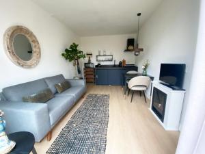 a living room with a blue couch and a table at The East Wing Bloemendaal in Bloemendaal