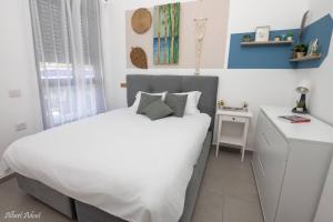 a bedroom with a white bed and a desk at Paradise in Achziv Beach in Nahariyya