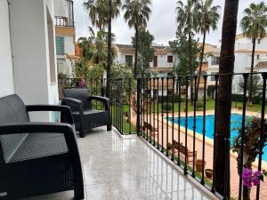 a balcony with a fence and a swimming pool at Apartamento EL PATIO V in Denia