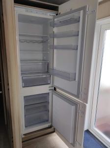 a refrigerator with its door open next to a window at Notre Nid in Middelkerke