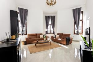 - un salon avec des canapés et une table basse dans l'établissement Kossuth Loft Apartment- Best location in downtown, à Veszprém