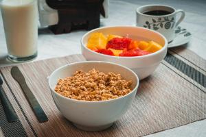 dos tazones de granola y fruta en una mesa en El Cocobolo Food&Rest Room 2 Bed and Breakfast WiFi AC Pkg gratis, 