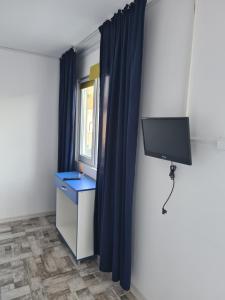 a room with a tv and a blue curtain at Holiday Village in Eforie Nord