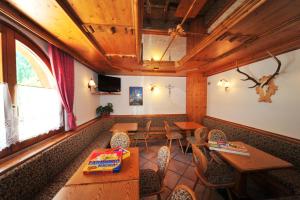 un restaurante con mesas de madera y sillas en una habitación en Agritur Ruatti, en Rabbi