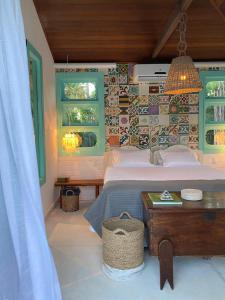 ein Schlafzimmer mit Bett, Tisch und Fenstern in der Unterkunft Casa Brasileira - Hotel Galeria in Pôrto de Pedras + 78 Fotos