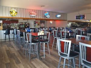 a bar with tables and chairs in a restaurant at Yellowstone River Inn in Glendive