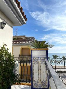 a house with a gate with the ocean in the background at Seafront apartment with rooftop terrace and pool in Calafell