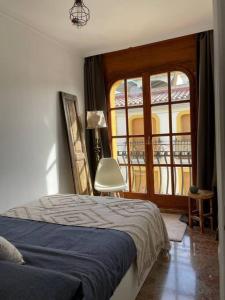 a bedroom with a bed and a large window at Seafront apartment with rooftop terrace and pool in Calafell
