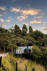 une maison au sommet d'une colline avec des arbres dans l'établissement Giüg Refugio, à Medellín