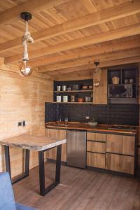 una cucina con soffitto in legno e tavolo in legno di Giüg Refugio a Medellín