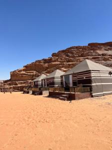 a row of houses on a sandy beach at Wadi Rum Sunset Camp in Wadi Rum