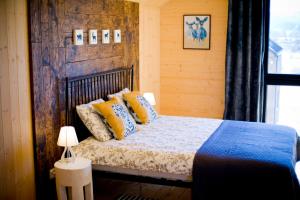 a bedroom with a bed with yellow and blue pillows at Dzikie Lisko - Apartamenty w Bieszczadach in Lesko