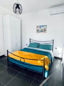 1 dormitorio con 1 cama con manta amarilla y azul en CASA DANI, en Tarquinia