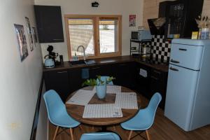 a kitchen with a table and chairs and a refrigerator at NOTRE CHALET - Boutique Hôtel - En couple - En famille - En groupe in Les Fourgs